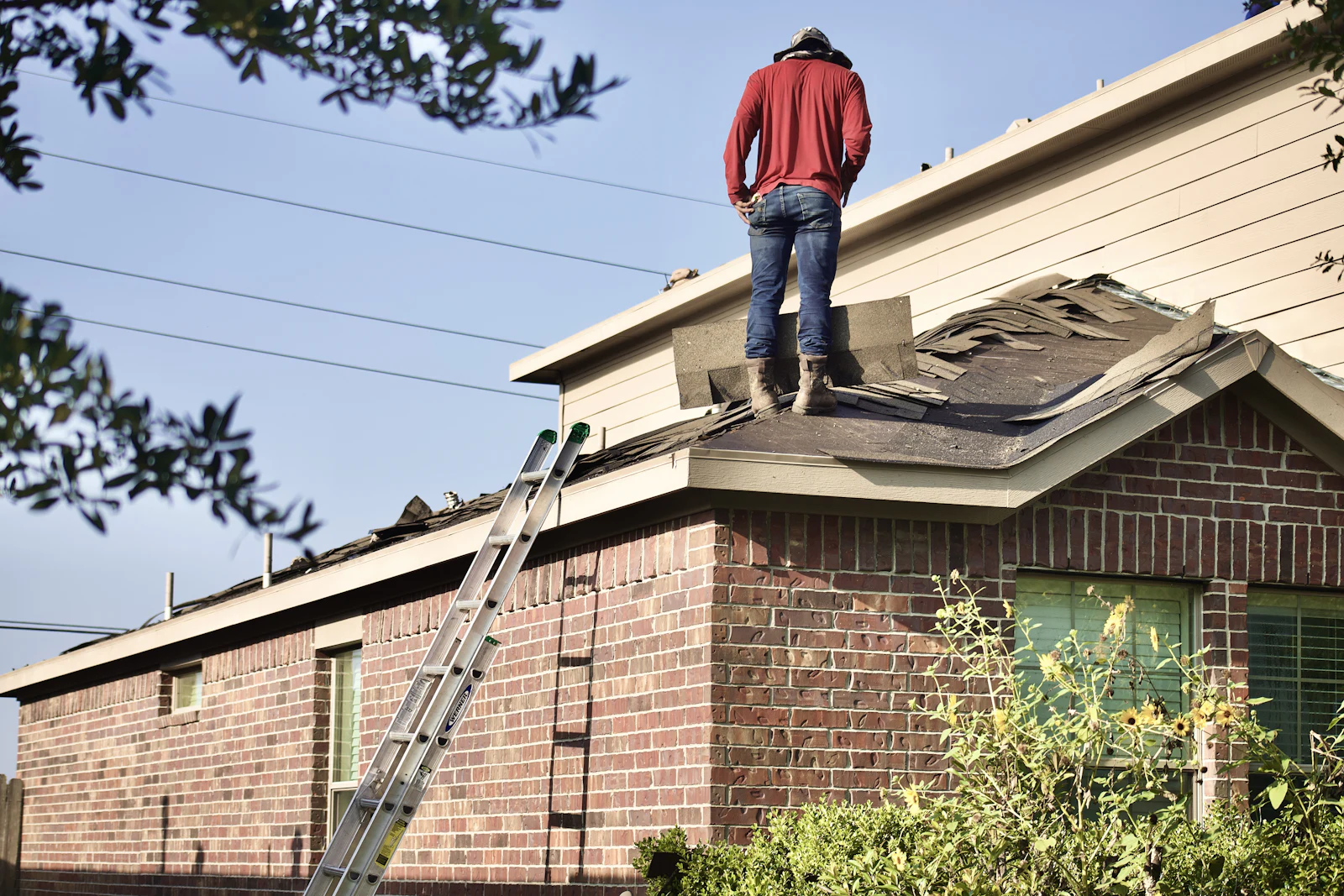 Texas insurance adjuster inspecting a brick home's roof for hail damage